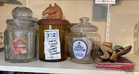 Overview of smoking mixture jars, pipe case, tin, and ashtrays arranged on shelf