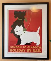 Full view of the framed travel poster showing the two dogs and the text 'London to Glasgow Holiday by Rail'
