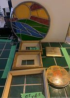 Photo showing the 3 wood mini frames, one marked 5x4, one compact with sailboat etching, and the round compact with color Scotland landmarks design, plus the round stained glass panel.