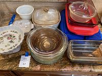 Overview photo of all glass and ceramic baking dishes on countertop showing various shapes and sizes, some with lids.
