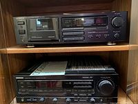 Front view of Kenwood KX-2520 cassette deck on top shelf and Kenwood KR-V7020 stereo receiver below, inside wooden shelf.