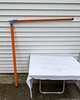 The pole fully extended vertically and top bar articulated horizontally showing the 'L' shape of the measuring pole on a white background outdoor setting.