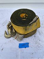 Pair of rolled yellow 3-inch wide winch straps with attached hooks on white surface, showing overall condition and packaging label