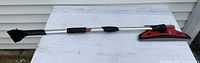 Full view of Garant snow brush showing aluminum handle, ice scraper on one end, and foam brush on the other.