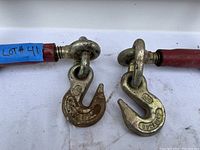 Close-up of two attached metal hooks, one marked with 'Dura-tek' and showing surface rust.