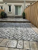 Backyard walkway with grey pavers in straight herringbone pattern