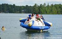Children on inflatable lake water toy participating in camp water activities