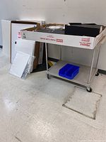 Metal rolling cart holding foam boards and storage bins