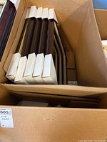 Five 16x20 picture frames with burl wood effect stacked in a box, each protected at edges by white corner covers.