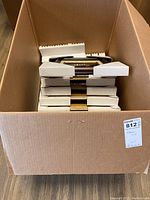 Boxed lot of stacked wooden picture frames with white foam corner protectors visible.