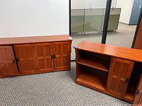 Photo of two cherrywood color credenza storage cabinets showing paneled doors and shelving.