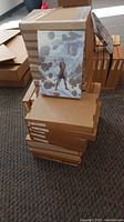 Stack of boxed canvas prints with two prints leaning on top