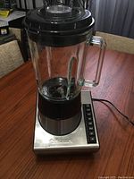 Front view of assembled Cuisinart blender with glass pitcher and lid on stainless steel base with control buttons.