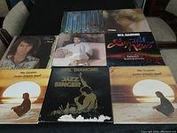 Photo of 8 Neil Diamond vinyl record albums arranged in two rows on a table
