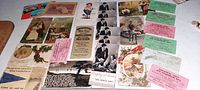 Photo showing various vintage postcards and advertising cards laid out featuring Halloween party themes, Victorian style cards and promotional store cards.