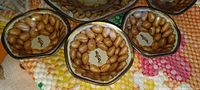 Close-up photo of four smaller tin litho cups showing peanut graphics and MR PEANUT at center