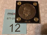 Front view of the 1973 S Eisenhower dollar coin in sealed black display case showing Eisenhower's profile and date.