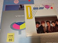 Photo showing all three albums partially stacked: Dire Straits Brothers in Arms, YES album, and Duran Duran self-titled album in shrink wrap.