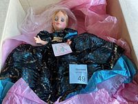 Madame Alexander 20 inch porcelain doll in original box wrapped in pink tissue paper, showing full outfit and packaging condition.