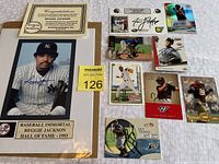 Full view of lot including framed Reggie Jackson autographed photo, certificate of authenticity, and nine signed sports cards arranged on a white surface.
