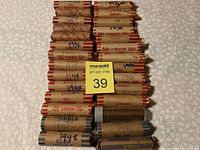 Full view of 24 penny rolls and 4 nickel rolls with handwritten date markings on wrappers