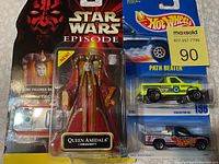 Packaged Star Wars Queen Amidala talking action figure and 2 Hot Wheels cars in original packaging.