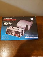 Box for the knock off NES entertainment system showing the console and controller graphics and the 500 built-in games, with Chinese text on the box.