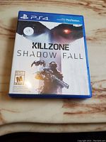 Front view of the Killzone Shadow Fall PS4 game case showing the cover art and rating sticker.