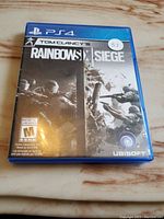Front cover of Tom Clancy's Rainbow Six Siege PS4 game case showing cover art and ESRB rating M.