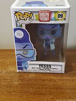Front view of boxed Funko Pop figure showing Yesss character with blue sunglasses and tablet.