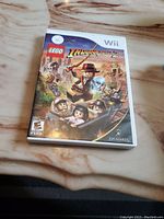Front cover of Wii LEGO Indiana Jones 2 game showing LEGO characters and rating.