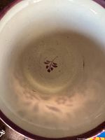 Close-up of the inside of the ceramic cup showing the purple floral motif and rim
