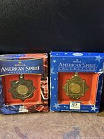 Two Hallmark American Spirit Collection Christmas ornaments inside original boxes, front view showing the coin centerpiece and packaging design