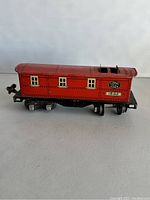 Side view of red metal Lionel 1682 train car with windows and Lionel Lines decal.