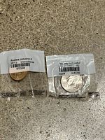 Two unopened plastic bags each containing one coin: Andrew Johnson 2011-D and Kennedy half dollar.