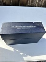Black storage box for the stamp collection, showing title label