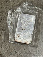 Silver Engelhard bar sealed in plastic showing front eagle design, serial number and purity stamps with visible toning spots
