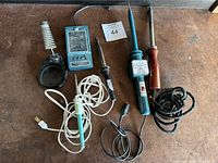 Lot includes four vintage soldering irons and a Heatkit Color Temperature Meter on a brown surface.