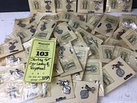 Overview of over 50 medallions on cards scattered on surface