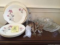 Full view of set showing plates, cake plate, platter, decanter, glasses, and crystal bowl with stopper wrapped separately.