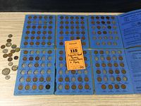 Folders with Lincoln Head Penny collections laid open showing multiple penny slots filled with coins identified by year and mint mark.