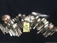 Full overview of the entire lot of mixed silver plate flatware showing spoons, forks, knives and ladles in various patterns and ages.