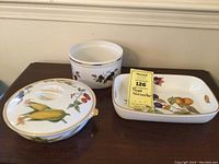 Three Royal Worcester Evesham casseroles shown with lids and one without lid, decorated with colorful fruits and vegetables with gold trim.