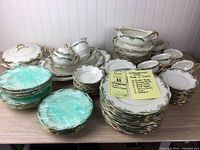 Full view of the full china set on table showing all items packed and stacked with a note listing contents of set.