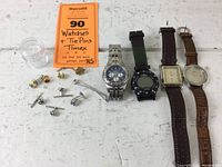Photo of a lot containing 4 wristwatches and multiple tie pins, showing watches with metal and leather bands and various tie pins in silver and gold tones.