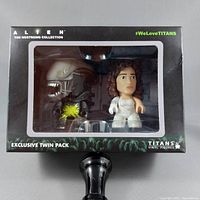 Front view of boxed exclusive twin pack showing Alien Xenomorph and human figure with white suit inside clear window.