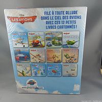 Back of sealed box showing all 12 book titles with illustrations and French text.