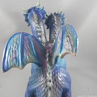 Rear view showing the wing and back textures of the two-headed colorful dragon figurine.