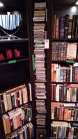 Tall column of jewel-case CDs on a black shelf alongside books