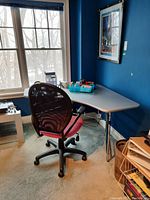 Side view of the EQ3 corner desk with metal base and office chair in front of a window with snowy outdoors.